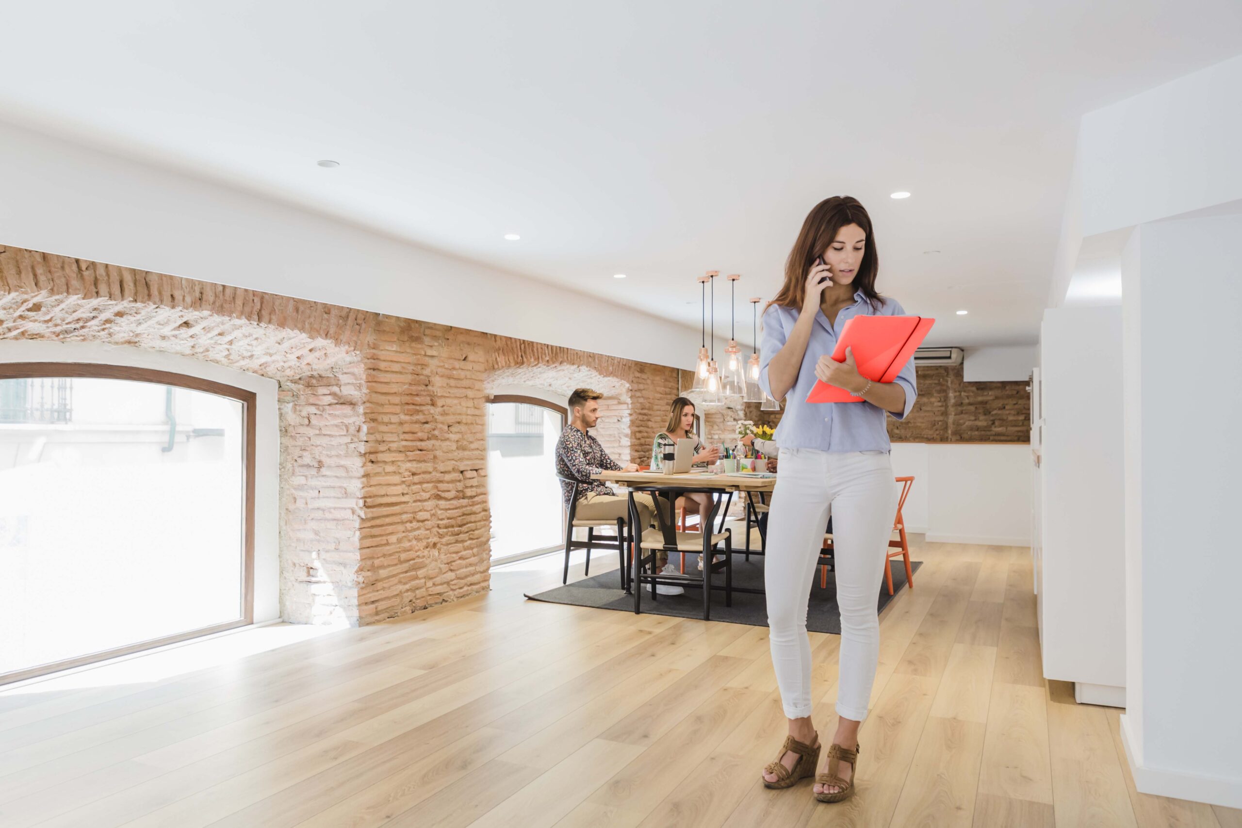 young-businesswoman-talking-phone-office red folder