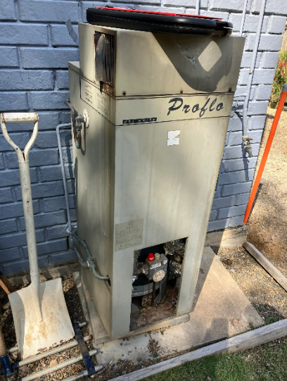 An image of a very old Proflo gas hot water system which needed replacing in Ipswich.