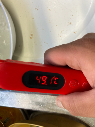 An image of the water temperature on a thermometer (displaying 49.1 deg) after to the hot water system repair.