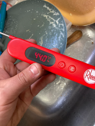 An image of the water temperature on a thermometer (displaying 44 deg) prior to the hot water system repair.