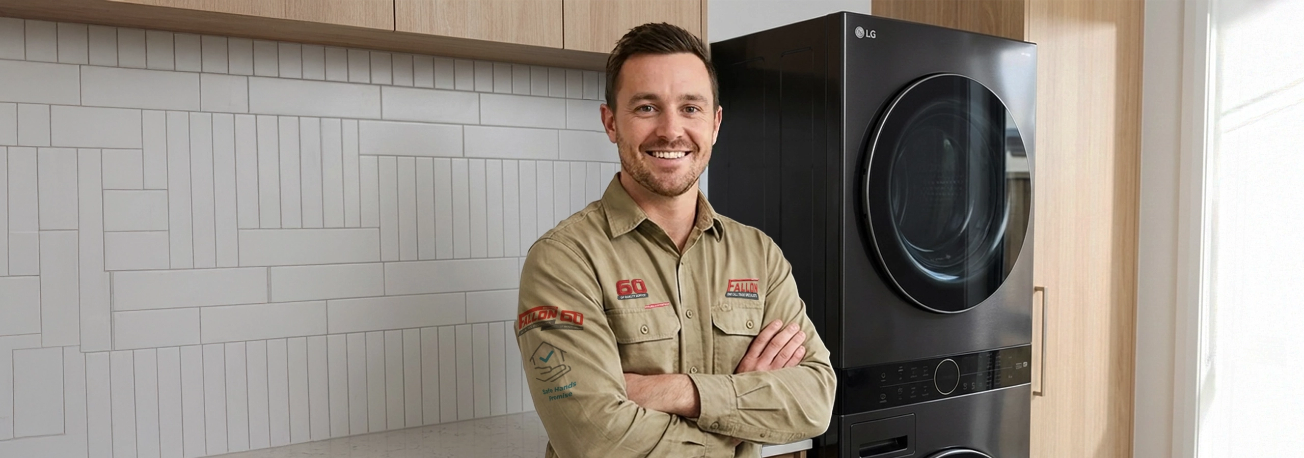 A smiling technician posing next to a modern black LG front-load washing machine in a laundry room.