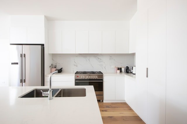 White kitchen with double door stainless steel fridge