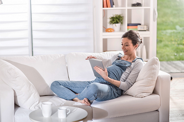 Woman sitting on lounge with tablet