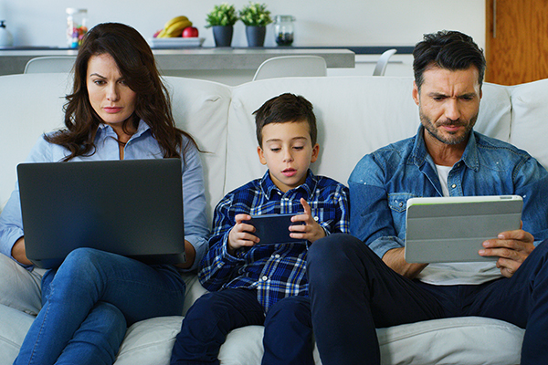 Family on lounge with devices